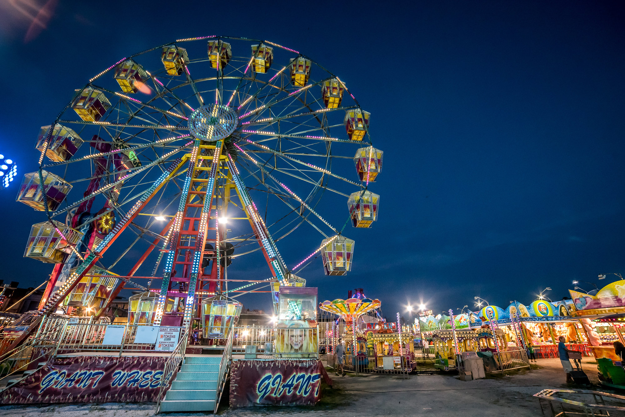 Sambill Park Giant Wheel and carnival rides illuminated at night